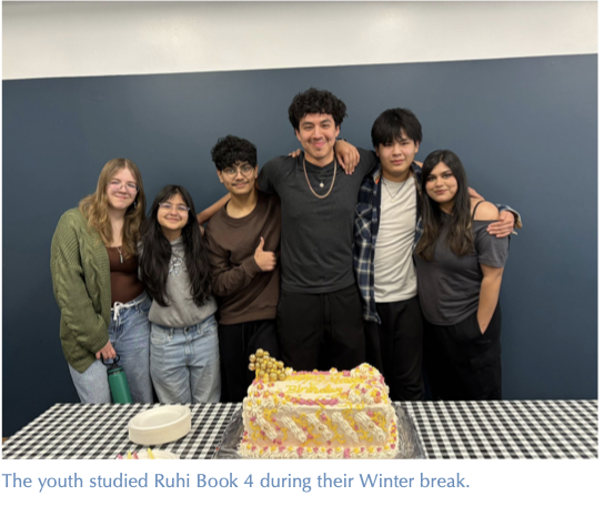 Youth who studied Ruhi Book 4 during their winter break gather behind a celebratory cake.