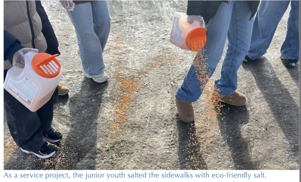 Junior youth spread eco-friendly salt on an icy sidewalk as a service project.